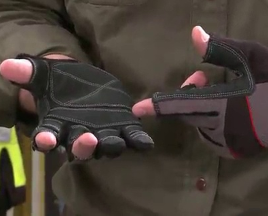 A close up picture of a person wearing fingerless work gloves